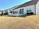 View of a backyard with a stone block wall, grass and neutral colored siding at 2918 Balbardie Dr, Apex, NC 27502