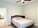 Well-lit bedroom featuring a simple bed with neutral bedding and a view into another room at 2918 Balbardie Dr, Apex, NC 27502