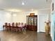 Bright dining room features a large table, hardwood floors, elegant chandelier and large china cabinet at 2918 Balbardie Dr, Apex, NC 27502