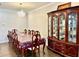 Bright dining room features a large table, hardwood floors, elegant chandelier and large china cabinet at 2918 Balbardie Dr, Apex, NC 27502