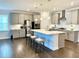 A spacious kitchen with stainless steel appliances, a center island with seating, and modern lighting fixtures at 2918 Balbardie Dr, Apex, NC 27502