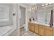 Bright bathroom featuring a double vanity, soaking tub, and separate toilet room at 3 Guilder Cv, Durham, NC 27713