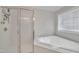 Bright bathroom featuring a soaking tub, shower, and window at 3 Guilder Cv, Durham, NC 27713