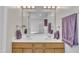 Bright bathroom featuring double vanity, purple towels, and mirror at 3 Guilder Cv, Durham, NC 27713