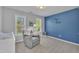 Charming Bedroom featuring a soft gray recliner, a changing table, and a delightful blue accent wall at 3 Guilder Cv, Durham, NC 27713