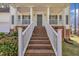 Inviting front porch with white railings and brick steps, perfect for relaxing and enjoying the outdoors at 3 Guilder Cv, Durham, NC 27713