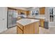 Kitchen featuring stainless steel appliances, center island with white countertops, and wood cabinets at 3 Guilder Cv, Durham, NC 27713