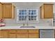 Kitchen sink with white countertop, wood cabinets, and window with blinds at 3 Guilder Cv, Durham, NC 27713