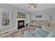 Bright living room features a fireplace with TV, ceiling fan, and windows enhancing the natural light at 3 Guilder Cv, Durham, NC 27713