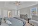 Spacious main bedroom with tray ceilings, ceiling fan, crib, dresser, and plentiful windows at 3 Guilder Cv, Durham, NC 27713