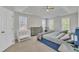 Spacious main bedroom with tray ceilings, ceiling fan, crib, dresser, and plentiful windows at 3 Guilder Cv, Durham, NC 27713