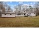 Expansive backyard with white house featuring metal roof, offering plenty of space for outdoor activities at 315 Dumont Dr, Hillsborough, NC 27278