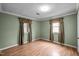Simple bedroom with wood flooring, green walls, and natural light at 315 Dumont Dr, Hillsborough, NC 27278