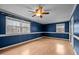 Bedroom features laminate floor, modern fan, and two bright windows at 315 Dumont Dr, Hillsborough, NC 27278