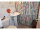 Bathroom features a pedestal sink and a vibrant colorful shower curtain at 3516 Apache Dr, Raleigh, NC 27609
