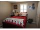 Cozy bedroom with a red bed, plush pillows, and a bedside table with a lamp at 3516 Apache Dr, Raleigh, NC 27609
