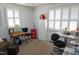 Bright bedroom featuring two windows with white shutters and office furniture at 3516 Apache Dr, Raleigh, NC 27609
