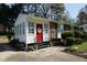 Inviting front porch features a red door, white sidelights and manicured landscaping at 3516 Apache Dr, Raleigh, NC 27609