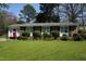 Charming brick home with a manicured front yard, trimmed shrubs and a vibrant red front door at 3516 Apache Dr, Raleigh, NC 27609