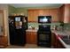 Traditional kitchen features wood cabinets, black appliances, countertops, and a black refrigerator at 3516 Apache Dr, Raleigh, NC 27609