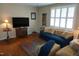 Comfortable living room featuring hardwood floors, a blue sofa and natural light from large windows at 3516 Apache Dr, Raleigh, NC 27609