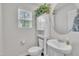 Cozy half bathroom featuring a pedestal sink, round mirror, and storage cabinet with foliage at 40 Poplar Bark Dr, Youngsville, NC 27596