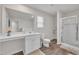 Well-lit bathroom features a large mirror, vanity, toilet, and a glass-enclosed shower at 40 Poplar Bark Dr, Youngsville, NC 27596