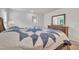 Cozy bedroom showcasing a wooden dresser, a large bed with a patterned quilt, and natural light at 40 Poplar Bark Dr, Youngsville, NC 27596