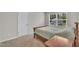 Cozy bedroom with neutral carpet and a wooden bed frame beneath a window at 40 Poplar Bark Dr, Youngsville, NC 27596