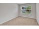 This bedroom has neutral carpet with a window view of neighborhood homes and trees at 40 Poplar Bark Dr, Youngsville, NC 27596