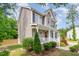 Two-story home showcasing the inviting front porch and decorative landscaping with shrubs and flowers at 40 Poplar Bark Dr, Youngsville, NC 27596