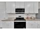 Modern kitchen with white cabinets, granite countertops, and stainless steel microwave at 40 Poplar Bark Dr, Youngsville, NC 27596