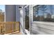 A view of the back porch with wood flooring, railings, a glass door and window on a grey house with grey siding at 404 Deercroft Dr, Apex, NC 27539