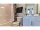 Well-lit bathroom featuring a white vanity and tub with shower with stylish shower curtain at 404 Deercroft Dr, Apex, NC 27539