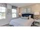 Bright bedroom features two large windows, a blue upholstered headboard and decorative wall art at 404 Deercroft Dr, Apex, NC 27539