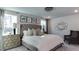 Inviting bedroom features elegant chandelier, decor, tufted headboard, side tables, and a cozy sitting chair at 404 Deercroft Dr, Apex, NC 27539