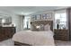 Comfortable bedroom with tufted headboard, bedside tables, lamps, neutral patterned linens and wall decor at 404 Deercroft Dr, Apex, NC 27539