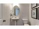 Well-lit powder room with pedestal sink, patterned wallpaper, and decorative accents at 404 Deercroft Dr, Apex, NC 27539