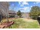 Large backyard features a lawn, mature trees, lake views and partial view of the home's rear elevation at 404 Vintage Hill Cir, Apex, NC 27539