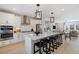 Bright open kitchen with white cabinets, stainless steel appliances and expansive island with bar stool seating at 408 Rowe Way, Knightdale, NC 27545