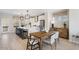 Open kitchen and dining area with long quartz island, stainless appliances and light hardwood flooring throughout at 408 Rowe Way, Knightdale, NC 27545