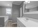 Bright bathroom with a single sink vanity, tub with tile surround, and wood look flooring at 41 Rock Bluff Ln, Kittrell, NC 27544