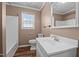 Bright bathroom with white fixtures, wood-look floor, and large window for natural light at 41 Rock Bluff Ln, Kittrell, NC 27544
