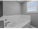 A close up of the relaxing whirlpool bathtub with tile surround and a window for natural light at 41 Rock Bluff Ln, Kittrell, NC 27544