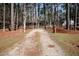 Long driveway leading to a home, framed by brick pillars and mature trees at 4105 Lassiter Rd, Wake Forest, NC 27587