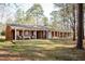 Sprawling brick home with inviting covered front porch and large mature trees at 4105 Lassiter Rd, Wake Forest, NC 27587