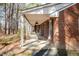 Inviting brick home featuring a sprawling covered front porch with rocking chairs and ample space for outdoor relaxation at 4105 Lassiter Rd, Wake Forest, NC 27587