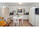 Cozy kitchen featuring white cabinetry and appliances, with a breakfast nook perfect for enjoying morning coffee at 4105 Lassiter Rd, Wake Forest, NC 27587