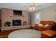 Cozy living room featuring a brick fireplace and leather couch with ottoman at 4105 Lassiter Rd, Wake Forest, NC 27587