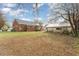 View of the property's backyard with a well-maintained lawn, detached garage and the home's exterior at 413 S Maple St, Graham, NC 27253